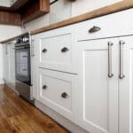 Freshly updated white kitchen cabinets showing when to refinish or replace kitchen cabinets based on cabinet condition, finish quality, and overall kitchen layout.