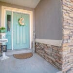 Freshly painted home exterior with stone accents and front door, showing how to prepare your home for exterior painting before a professional project begins