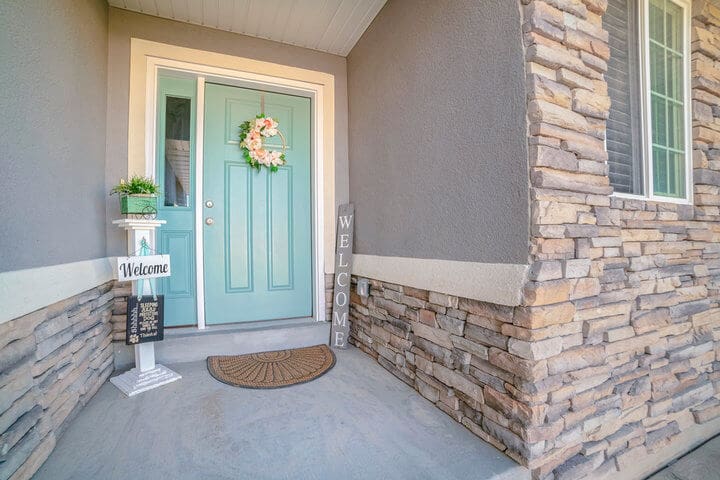 Freshly painted home exterior with stone accents and front door, showing how to prepare your home for exterior painting before a professional project begins