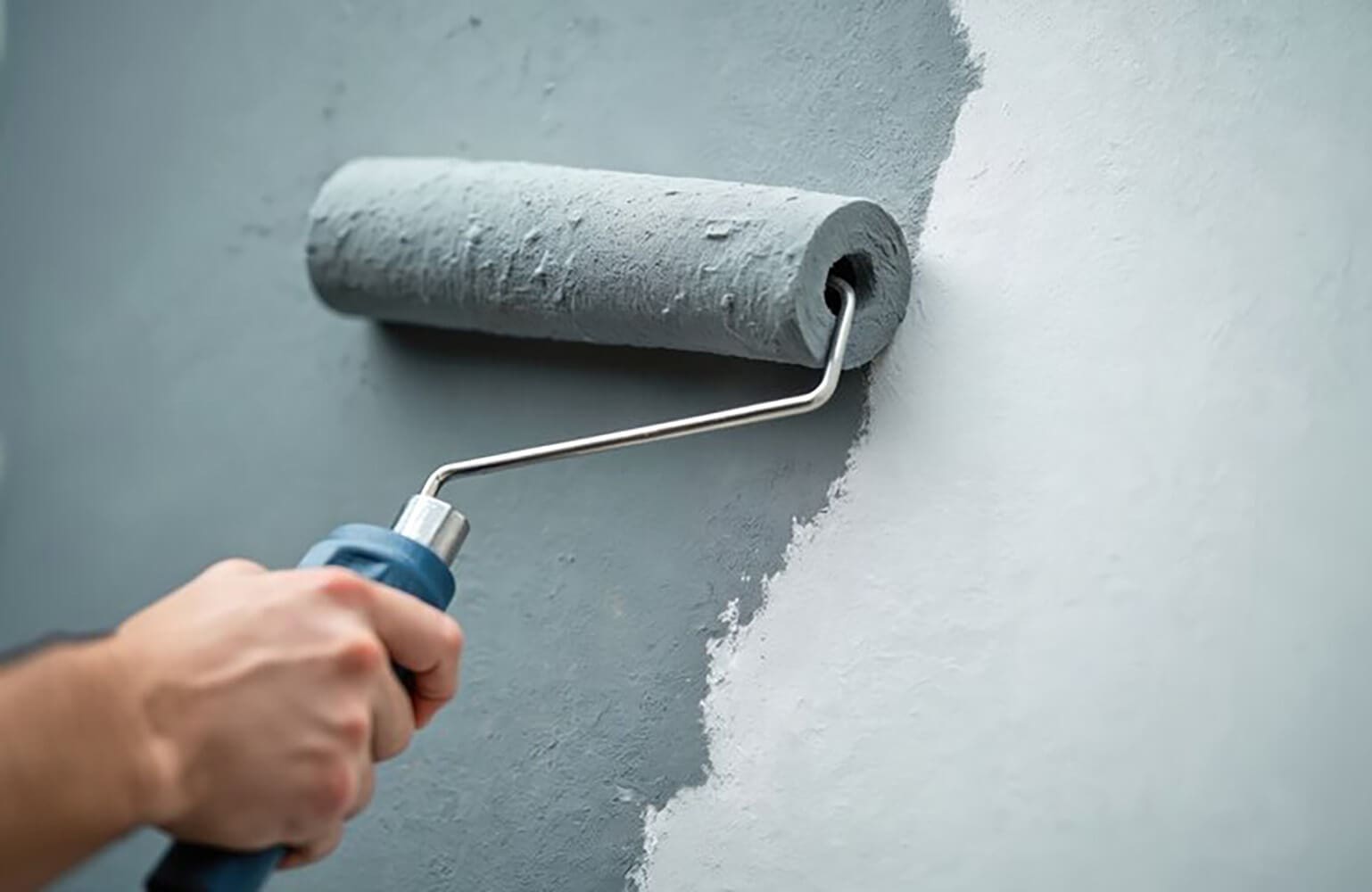 Interior paint colors that make rooms look larger applied with a roller, showing light gray paint creating a brighter, more open wall surface