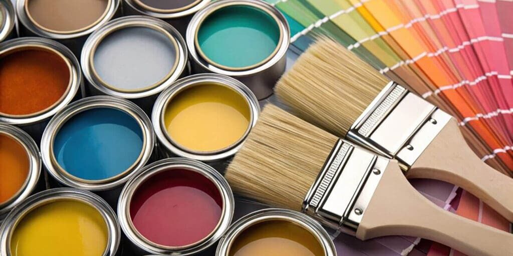 Best paint finishes for busy living areas shown with open paint cans, color swatches, and paint brushes laid out for interior painting projects