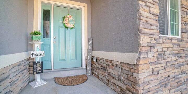 Freshly painted home exterior with stone accents and front door, showing how to prepare your home for exterior painting before a professional project begins